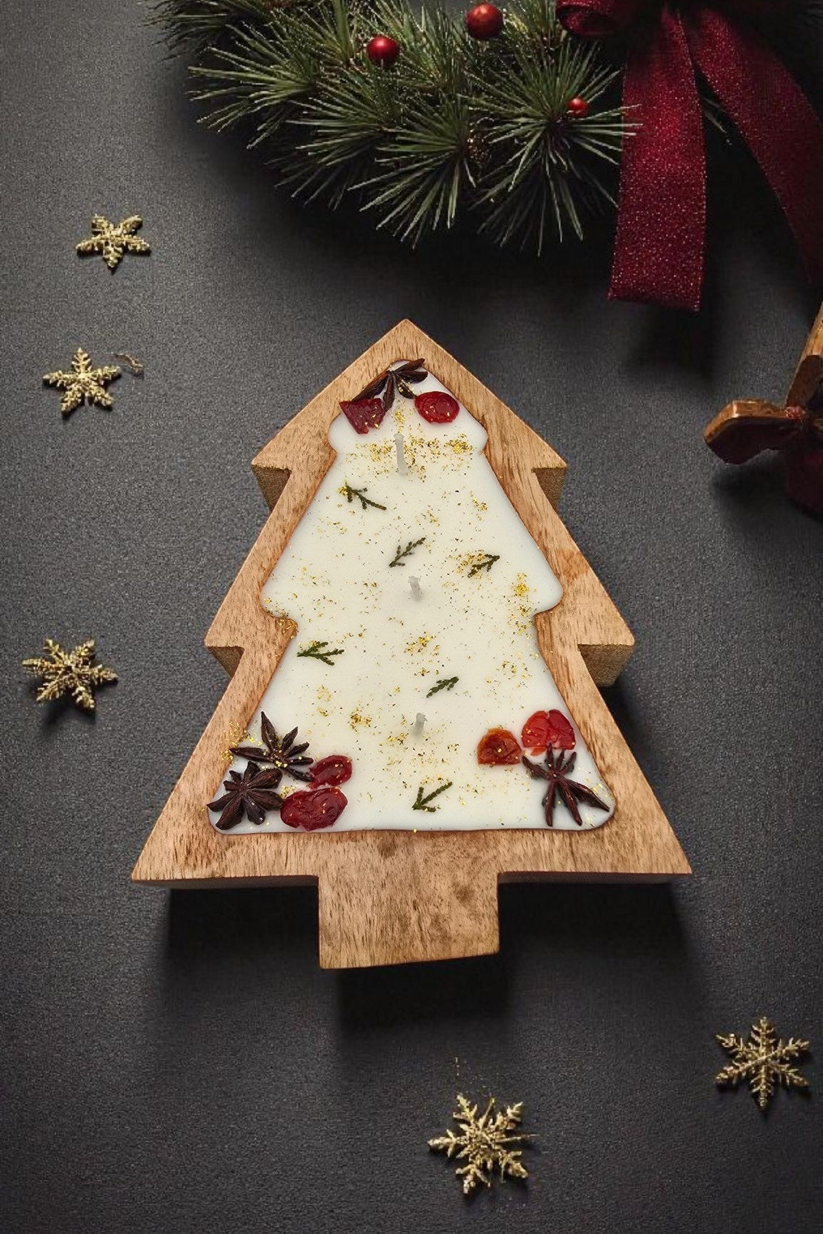Wooden Christmas tree decoration with white paper, red berries, and gold stars on a dark background.