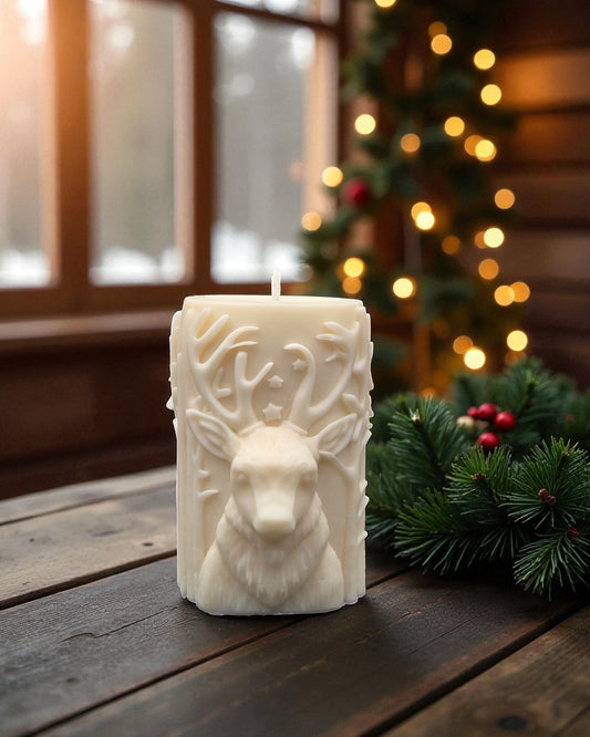 Decorative candle with deer design on a wooden surface with Christmas decorations in the background.