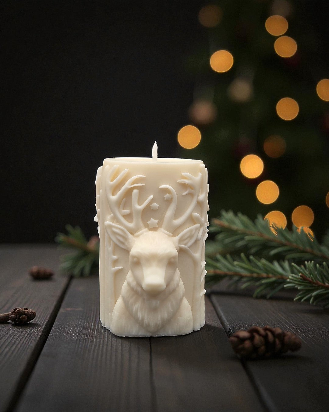 Decorative candle with deer design on a wooden surface with Christmas decorations in the background