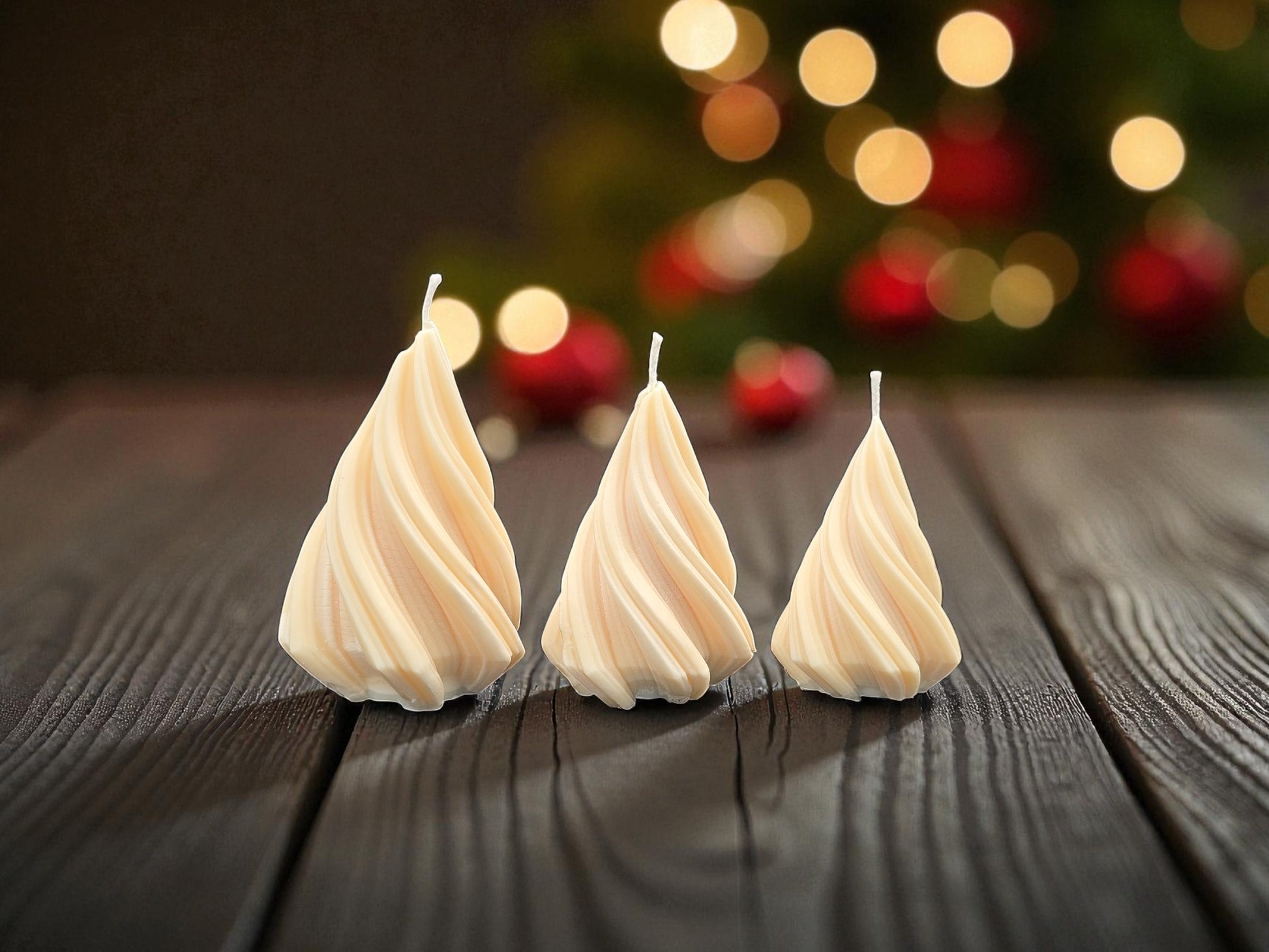 Three swirled candles on a wooden surface with a blurred festive background