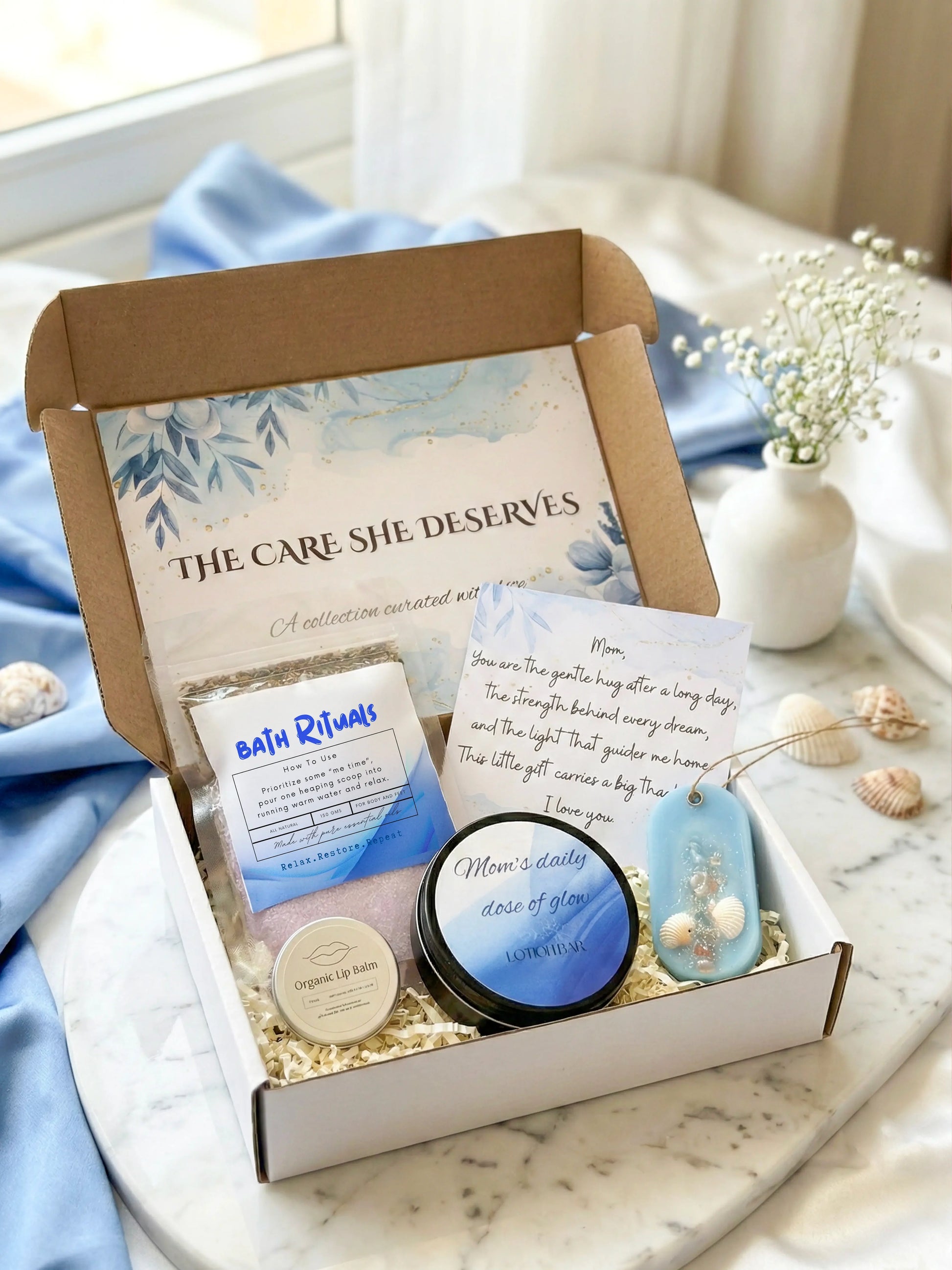 Gift box with bath products and a card on a marble surface