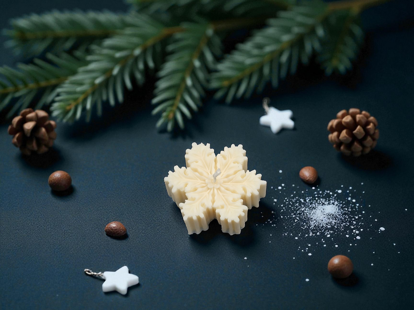 Snowflake-shaped white candy on a dark surface with pine branches and pinecones.